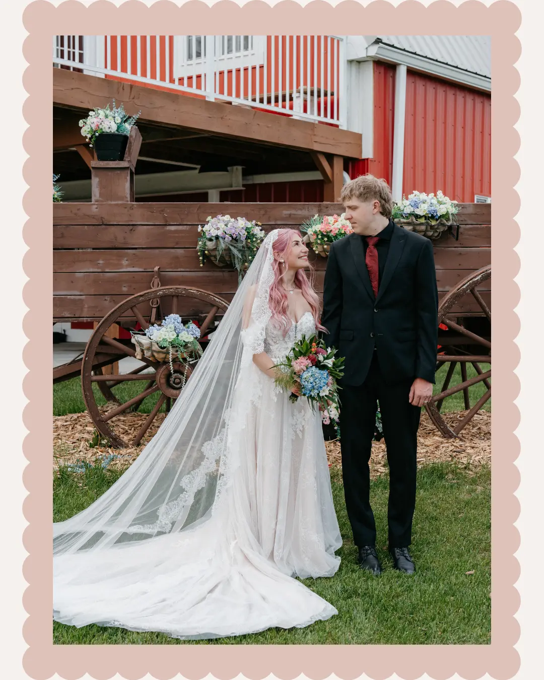 Brooks and Sammie posing beside the flower-decorated wagon at The Heritage Centre wedding venue near Cremona, Alberta