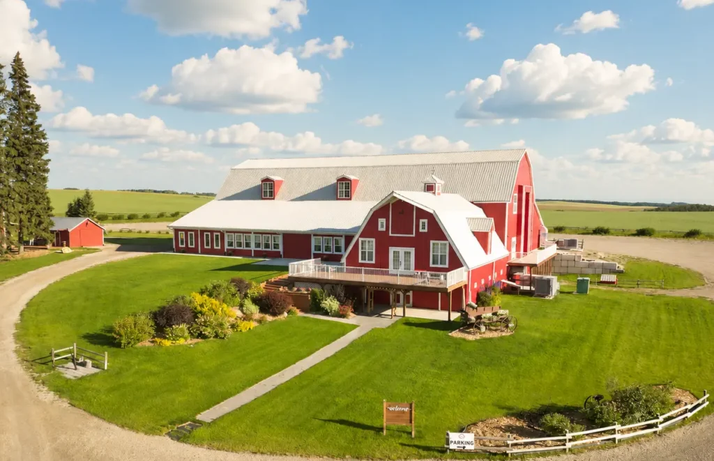 The Heritage Centre Alberta Wedding Venue Aerial View | The Heritage Centre by Mountain View Events Ltd. | The Heritage Centre by Mountain View Events Ltd. Aerial view of The Heritage Centre red barn wedding venue, landscaped grounds and Alberta countryside in Cremona near Calgary.