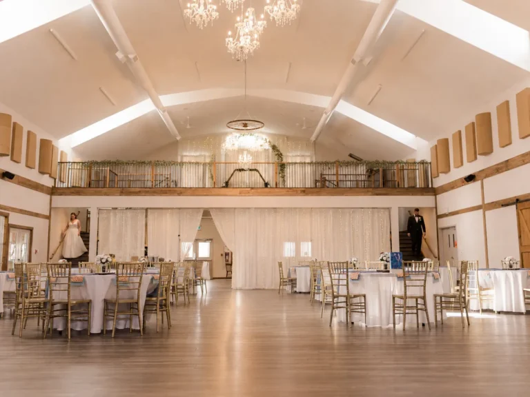 Bride and groom walking down opposite staircases in the Grand Ballroom at The Heritage Centre.
