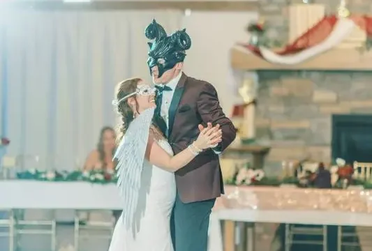 Bride and groom wearing masquerade masks dancing in the Grand Ballroom.