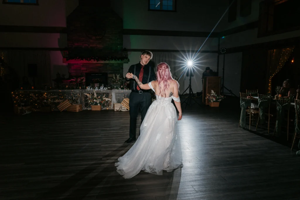 Newlywed couple dancing beneath reception lights in the Grand Ballroom.