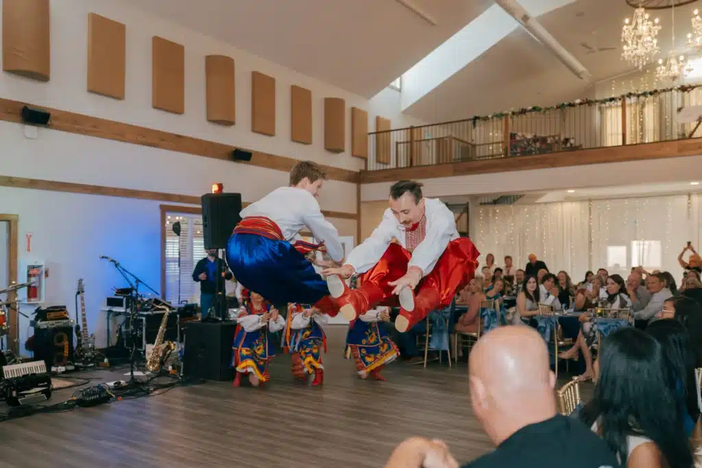 Ukrainian male dancers leaping during a wedding reception in the Grand Ballroom.