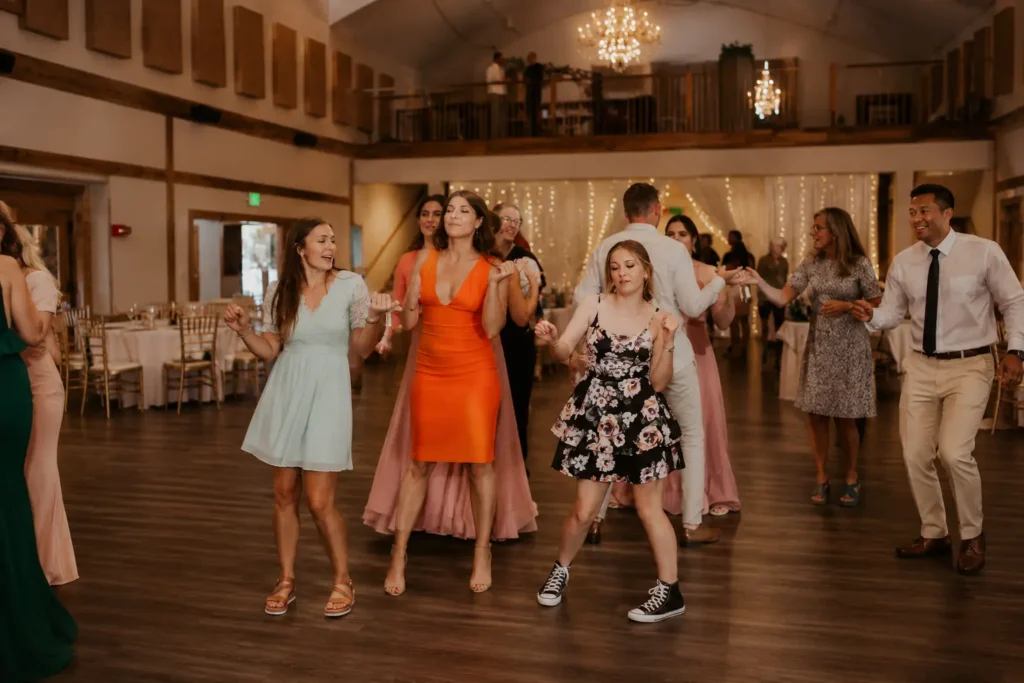 Wedding guests dancing together in the chandelier-lit Grand Ballroom.