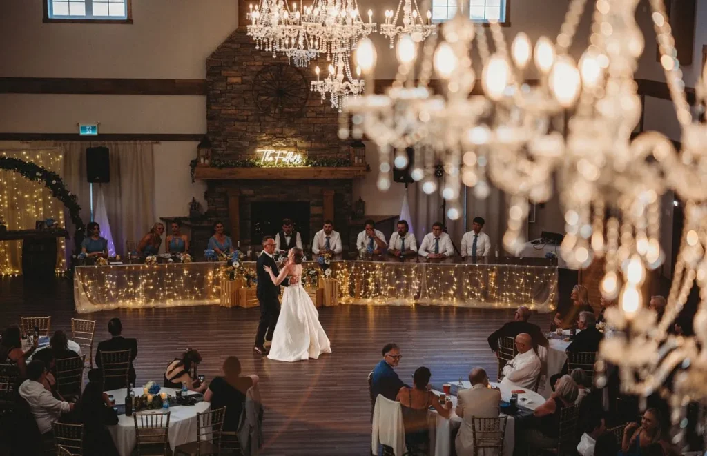 Newlywed couple dancing beneath chandeliers in The Heritage Centre Ballroom.