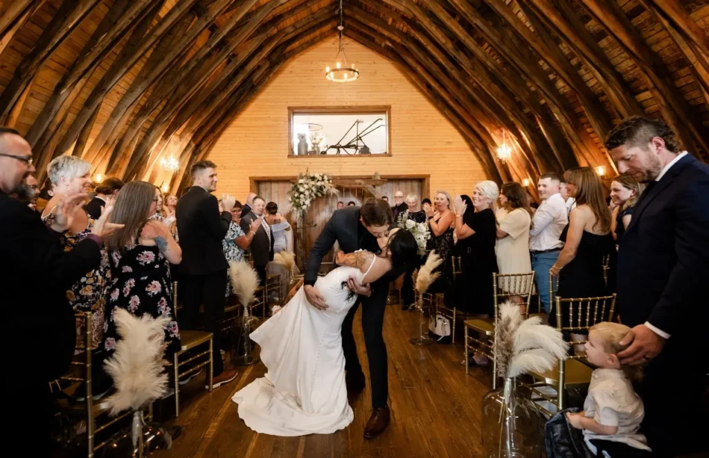 Newlywed couple celebrating after an indoor wedding ceremony in The Heritage Centre Historic Barn.